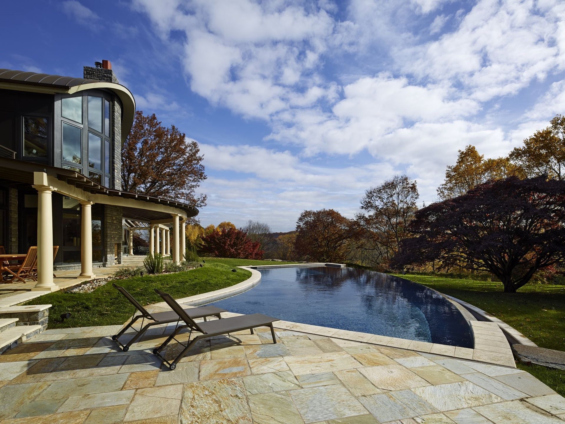 A large house with a swimming pool in front of it