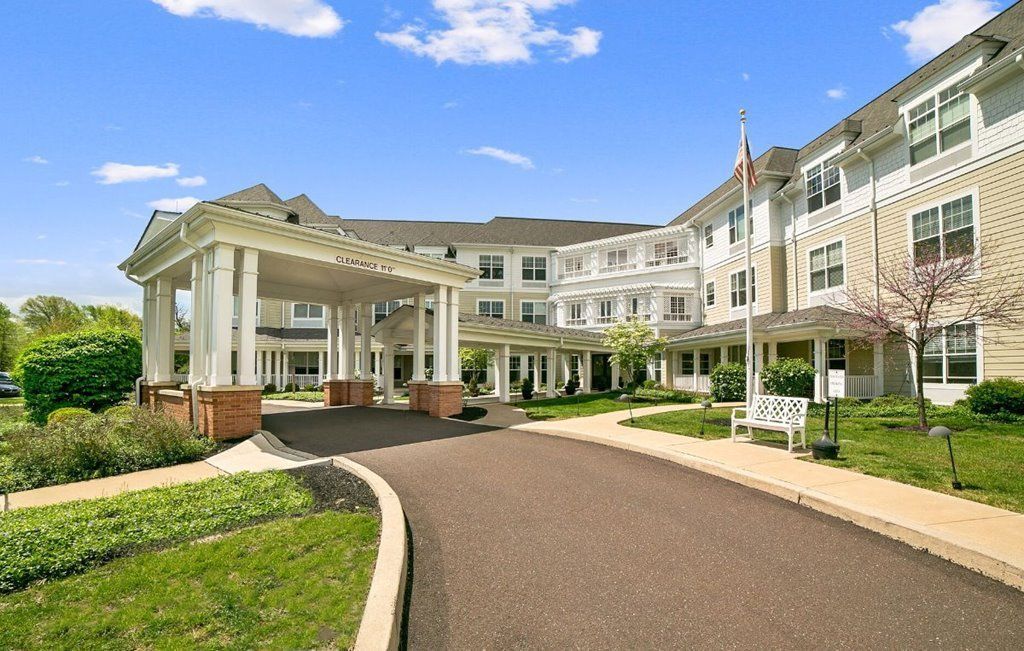 A large building with a lot of windows and a driveway leading to it.