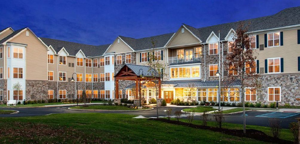 A large apartment building with a lot of windows is lit up at night.