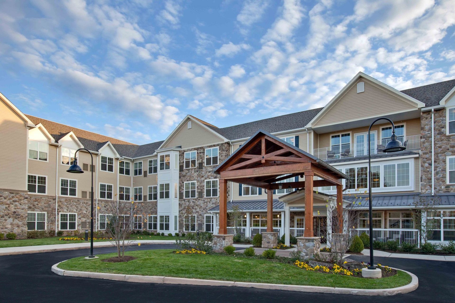 A large apartment building with a wooden gazebo in front of it