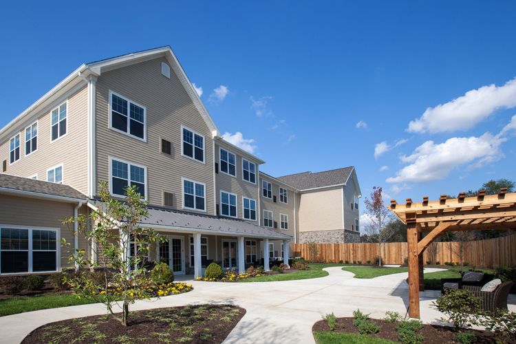 A large apartment building with a pergola in front of it.