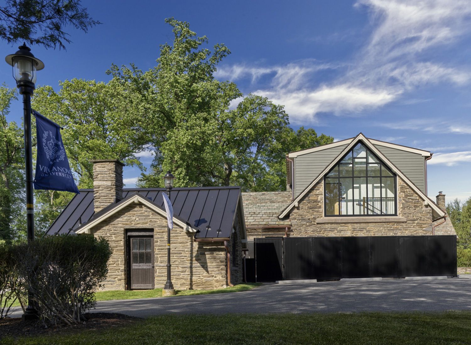 A brick house with a black roof and a large window