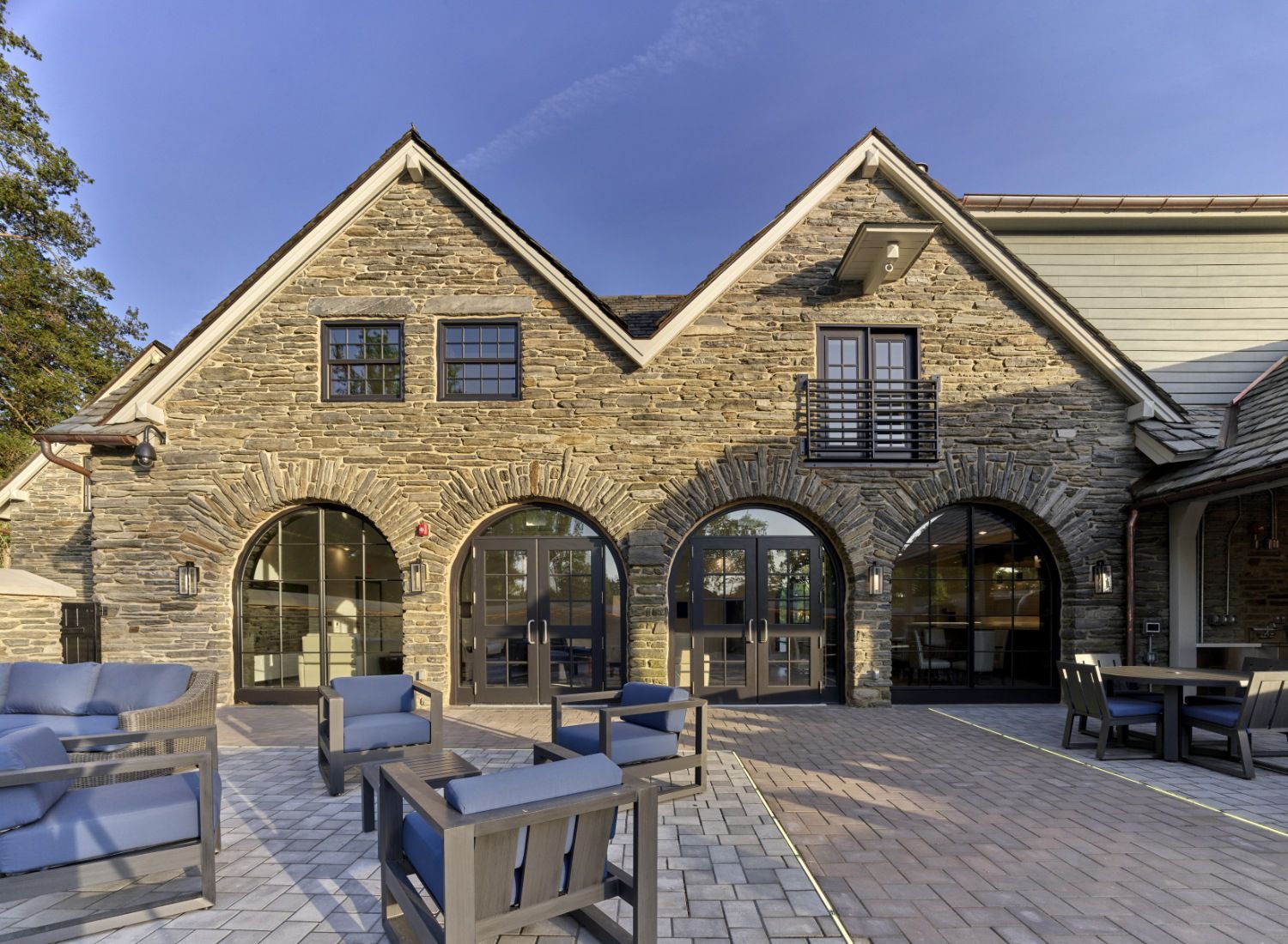 A large stone building with a patio area in front of it.
