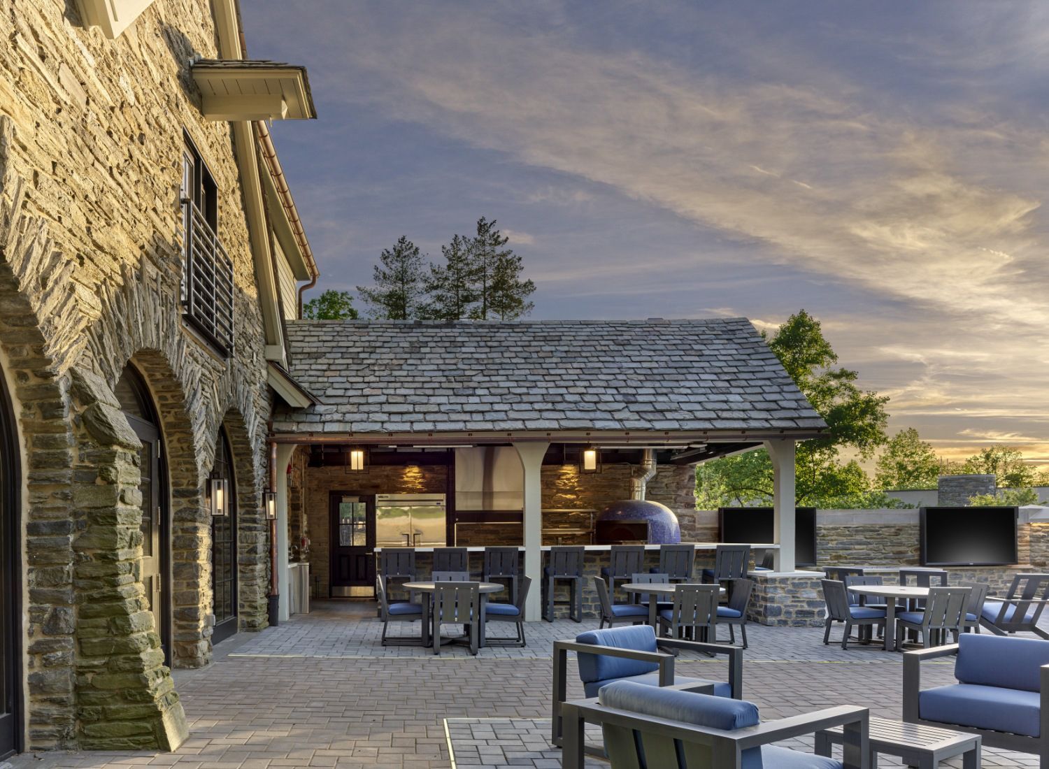 A patio with tables and chairs in front of a stone building