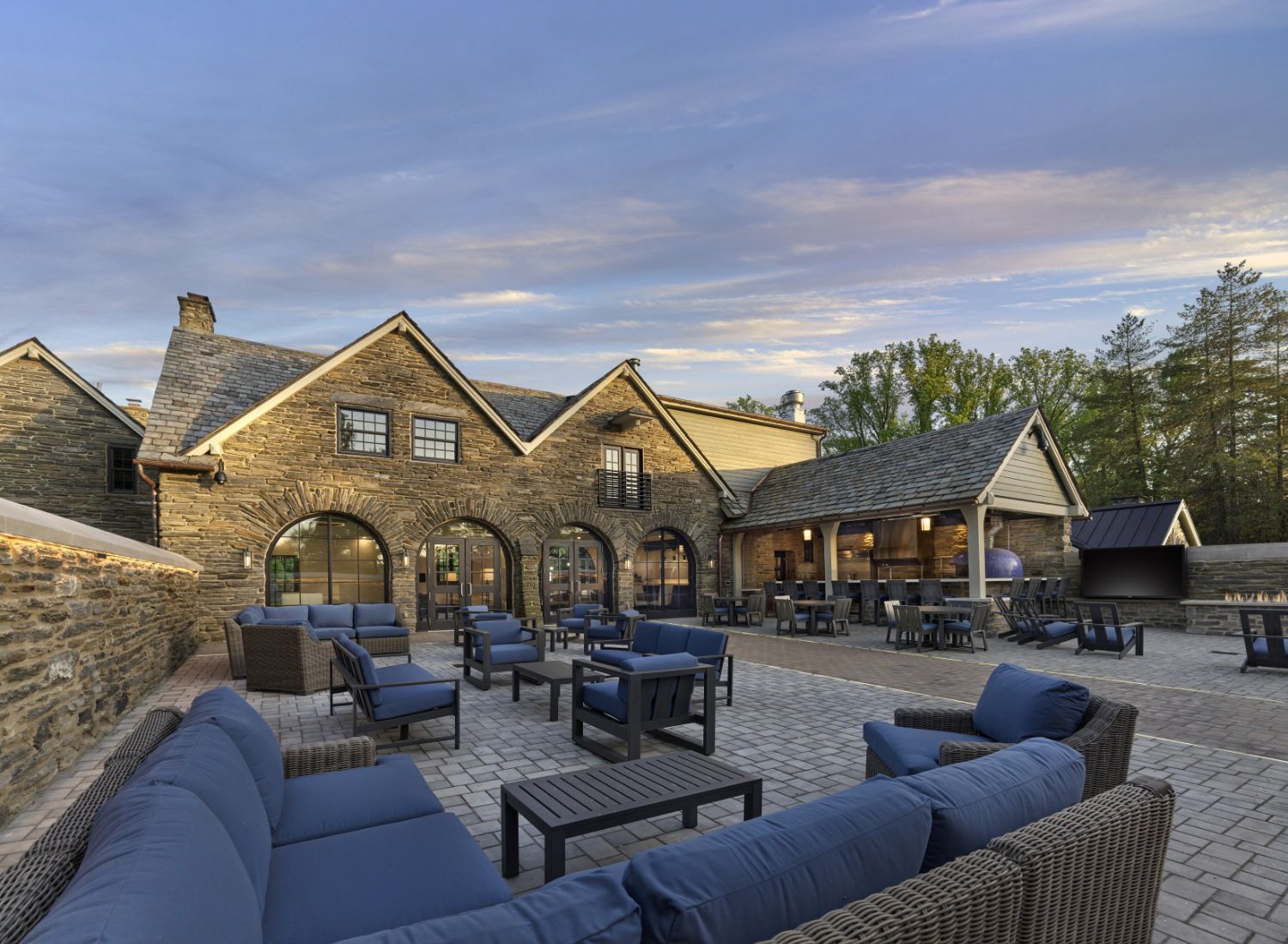 A large stone building with a lot of furniture in front of it.