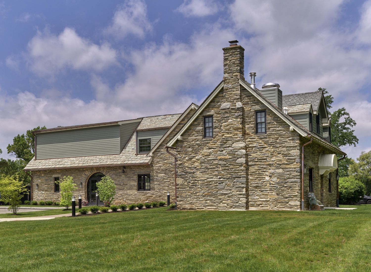 A large stone house with a chimney on top of it