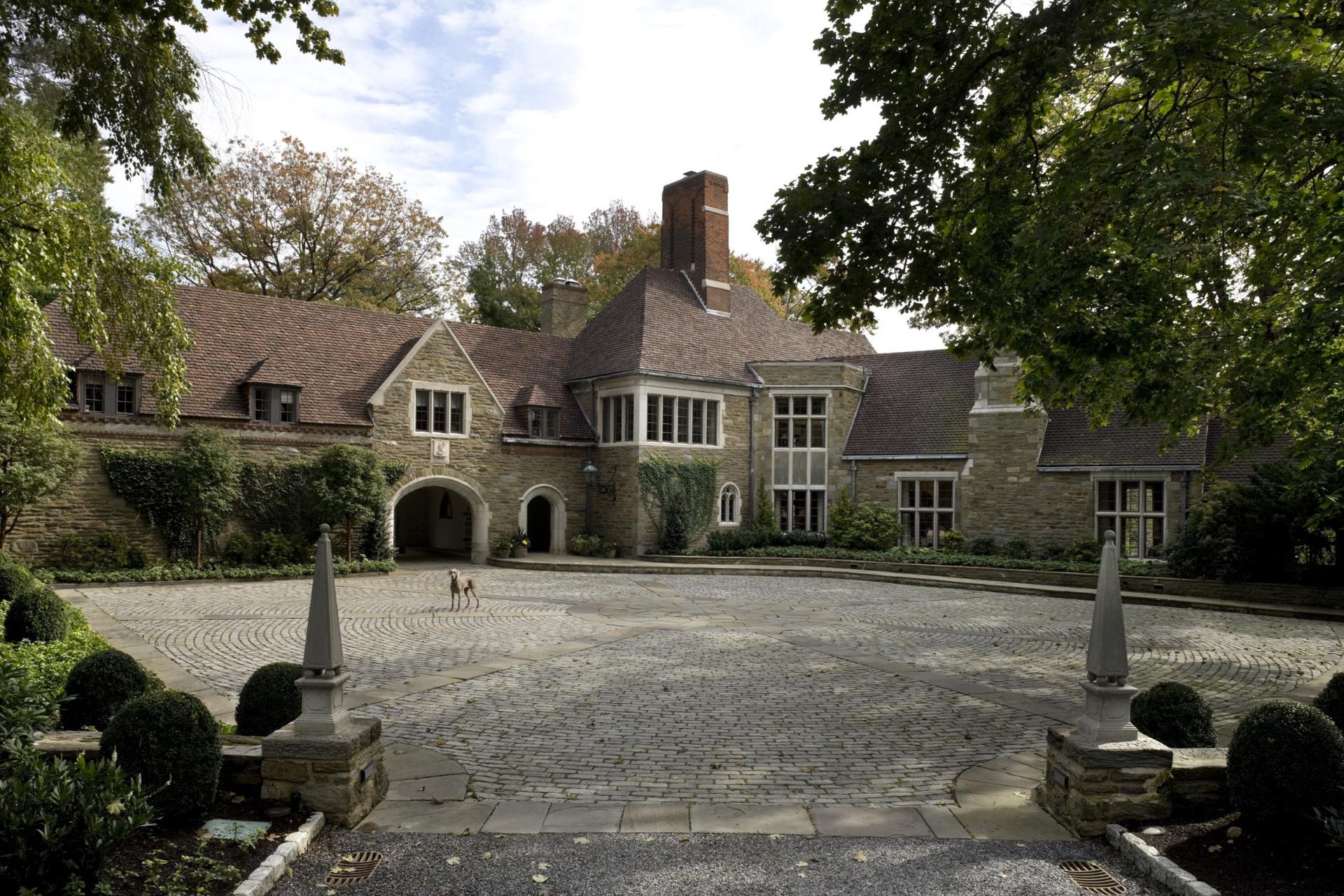A large stone house with a driveway leading to it