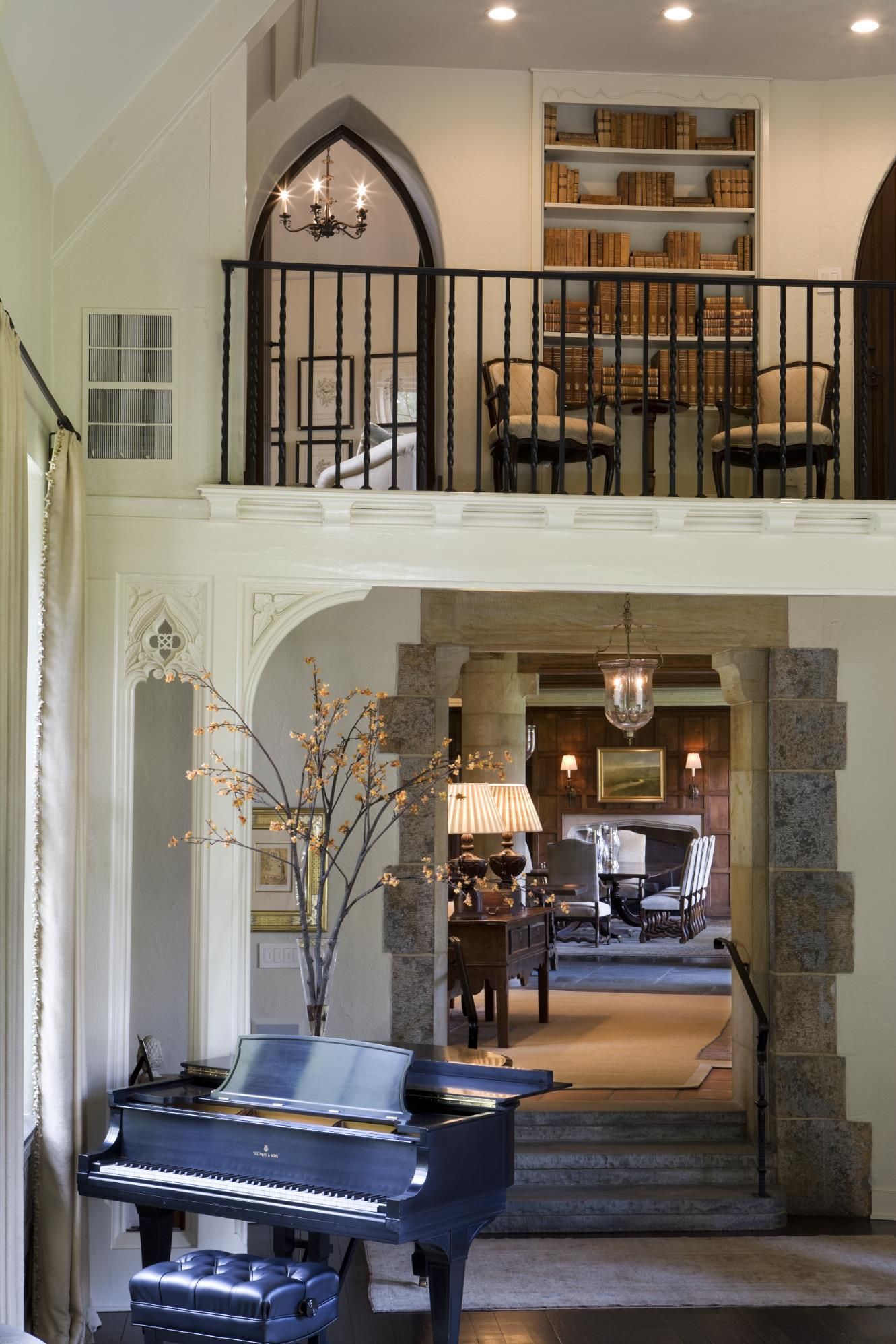 A piano in a room with a balcony above it