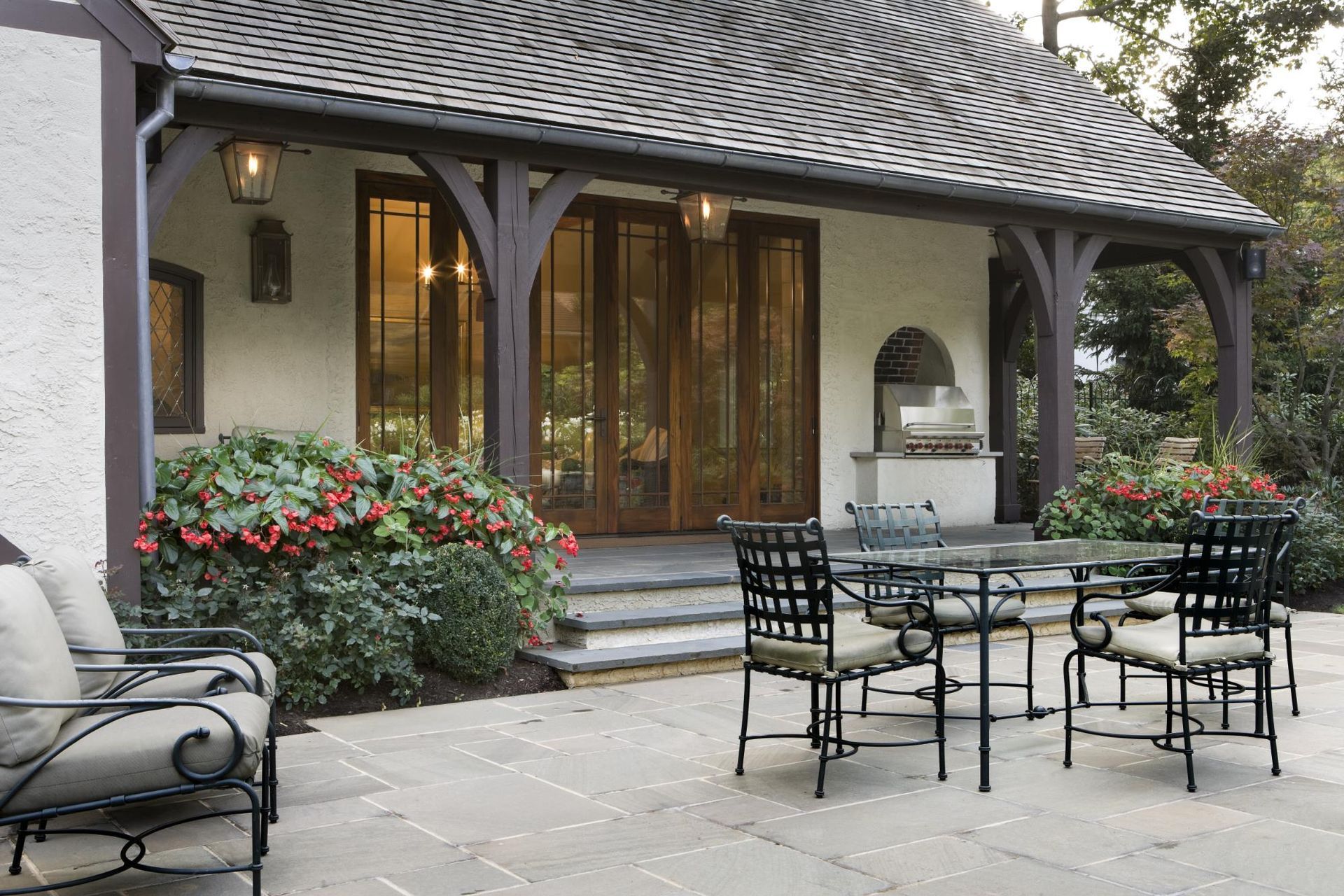 A patio with a table and chairs in front of a house