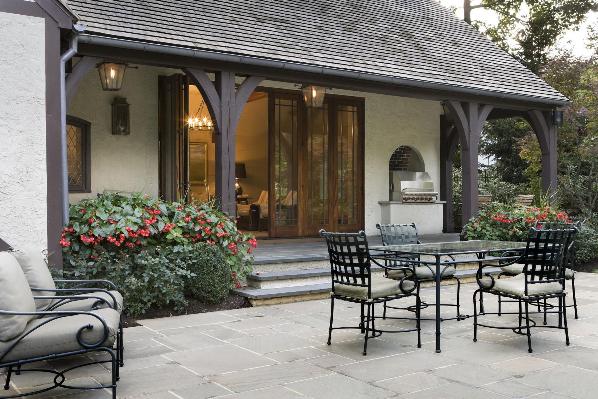 A patio with a table and chairs in front of a house