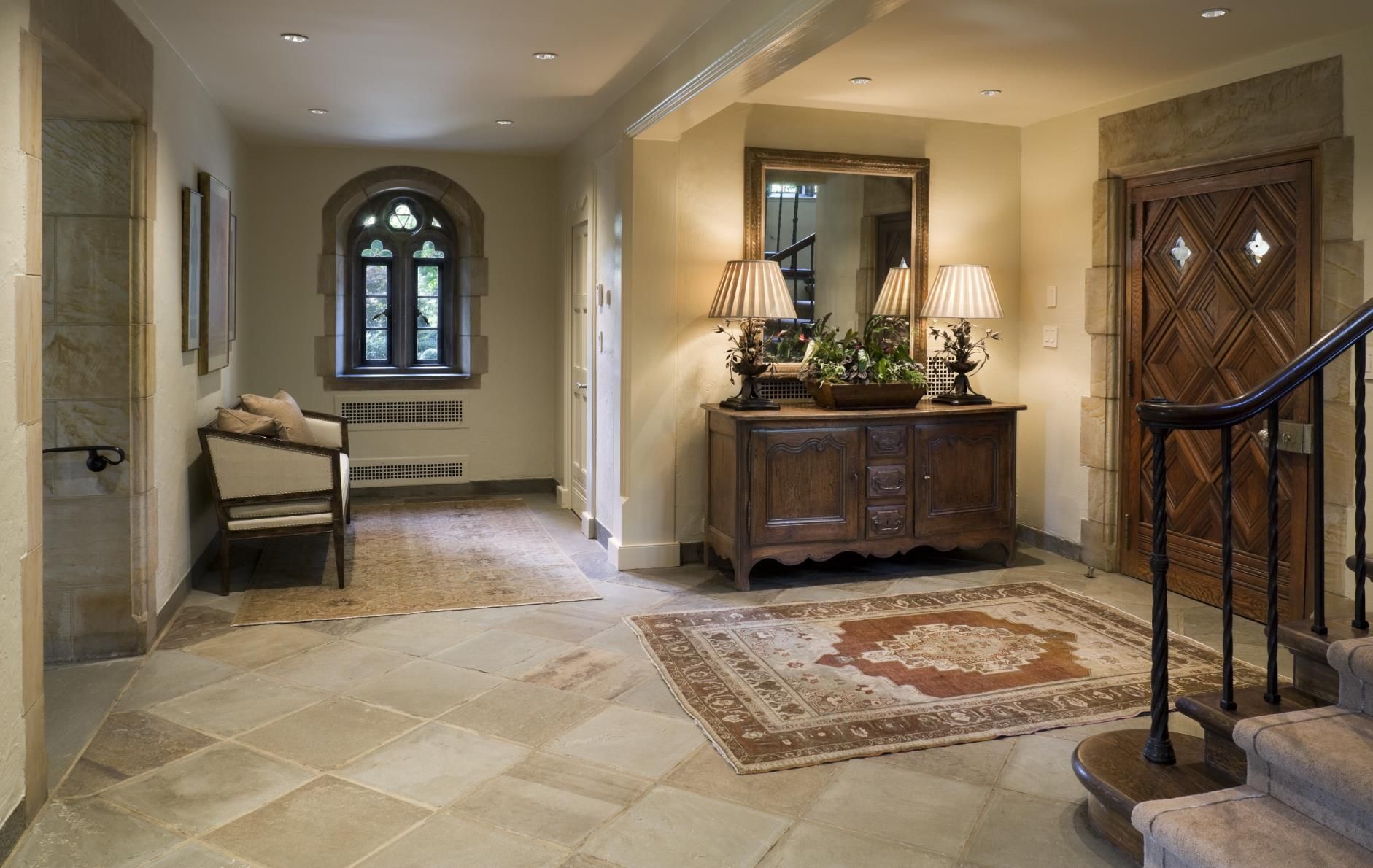 A hallway in a house with a rug and a mirror
