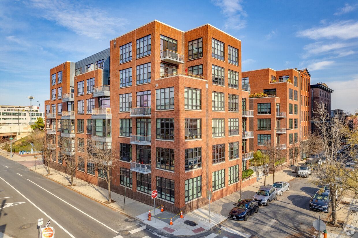 An aerial view of a large brick apartment building next to a street.
