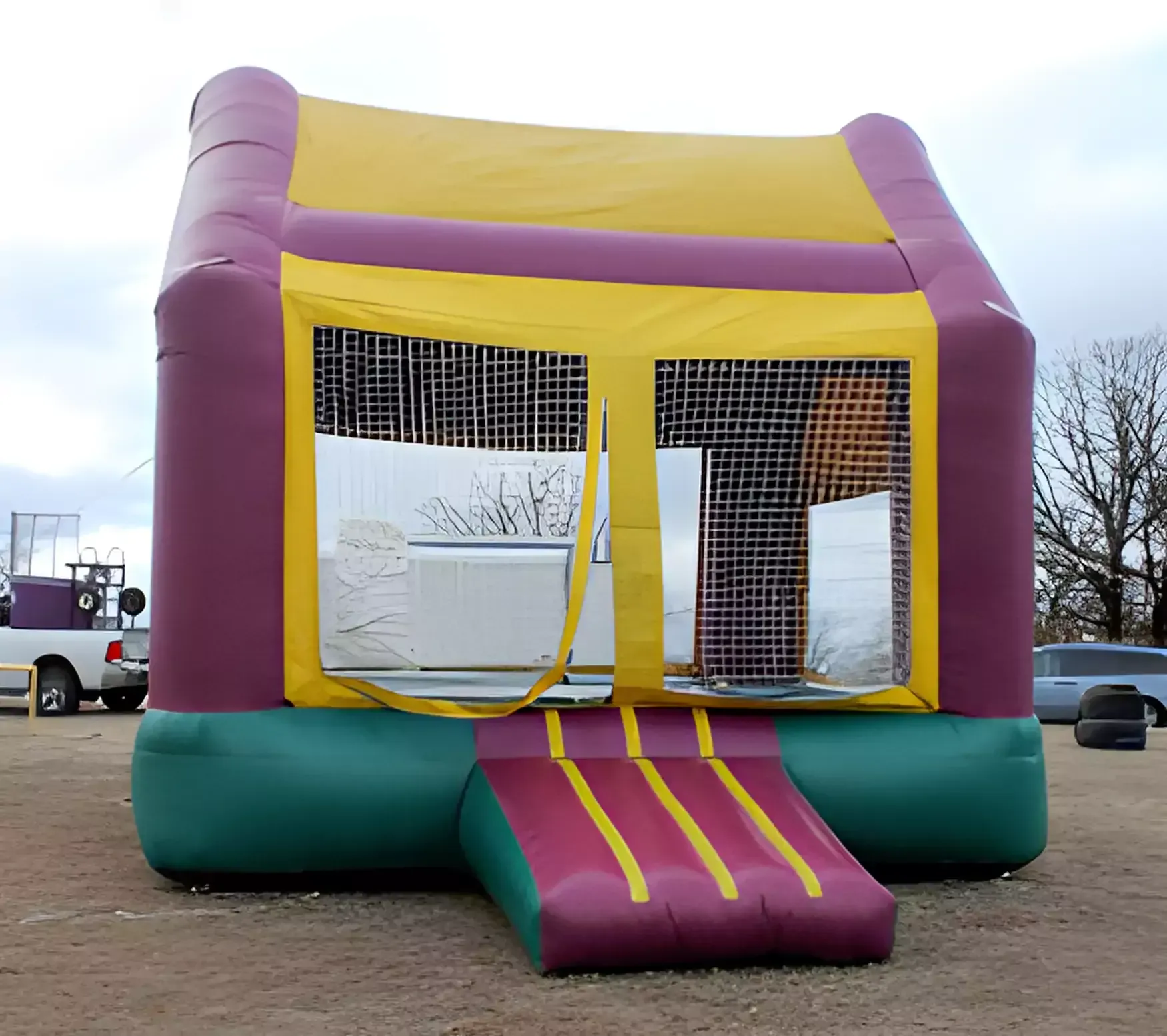 A purple and yellow bouncy house in a parking lot