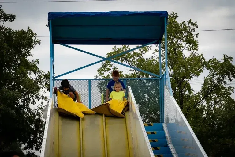 A group of children are riding down a slide.