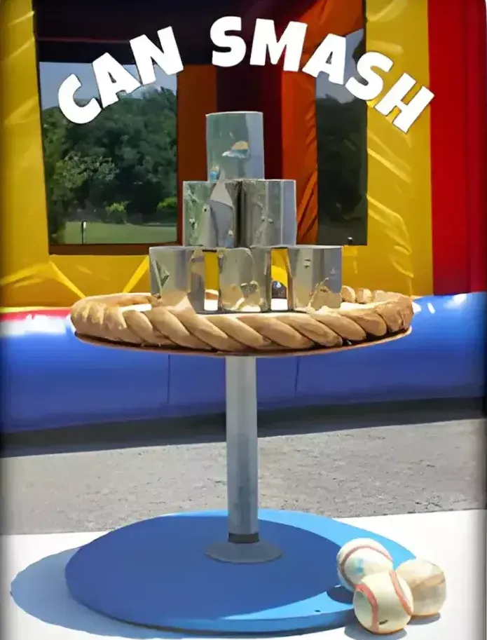 A picture of a can smash game with a bouncy house in the background
