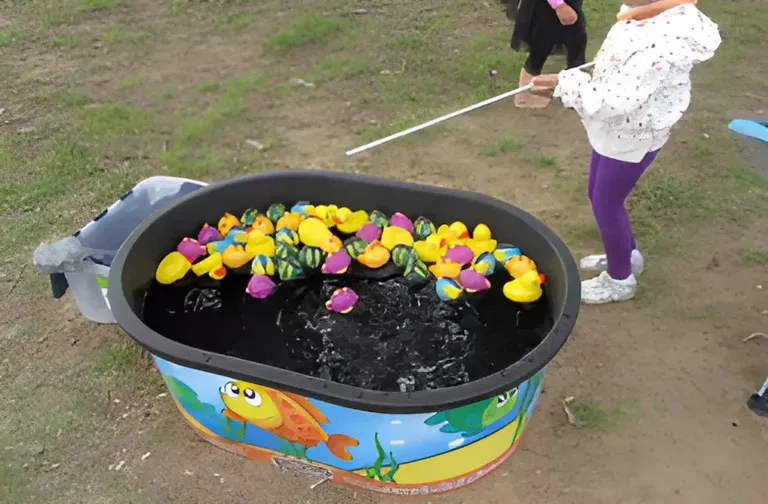 Two children are playing with rubber ducks in a pool