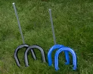 Two horseshoes are sitting on top of a lush green field.