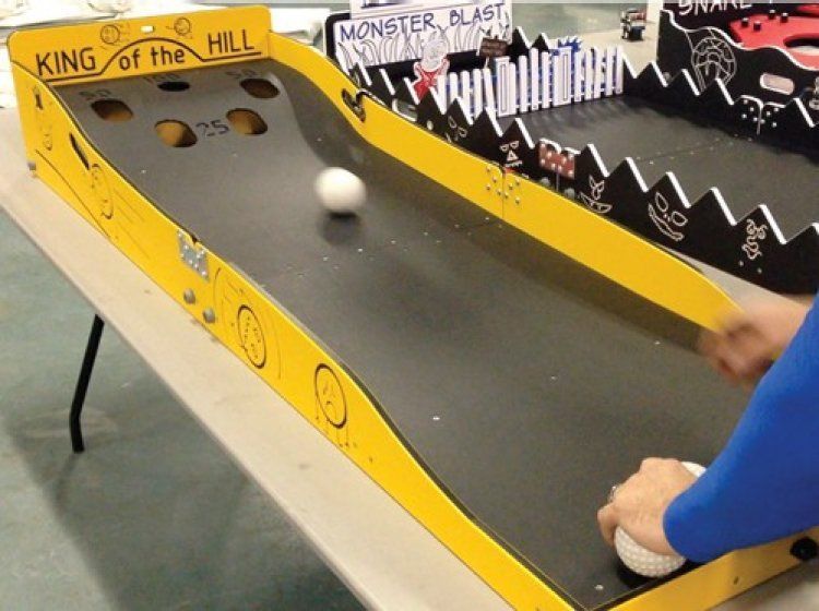 A person is playing king of the hill on a table