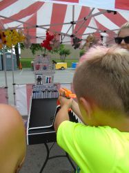 A young boy is playing a game at a carnival.