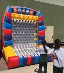A group of people are standing in front of a large inflatable game.