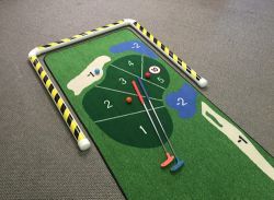 A small golf mat with a golf club and ball on it.