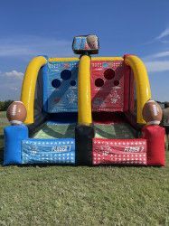 An inflatable football game is sitting on top of a lush green field.
