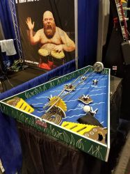 A table with a game on it and a picture of a man playing drums.