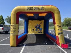An inflatable sports speed game is sitting in a parking lot.