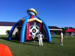 A group of people are standing in front of an inflatable ufo.