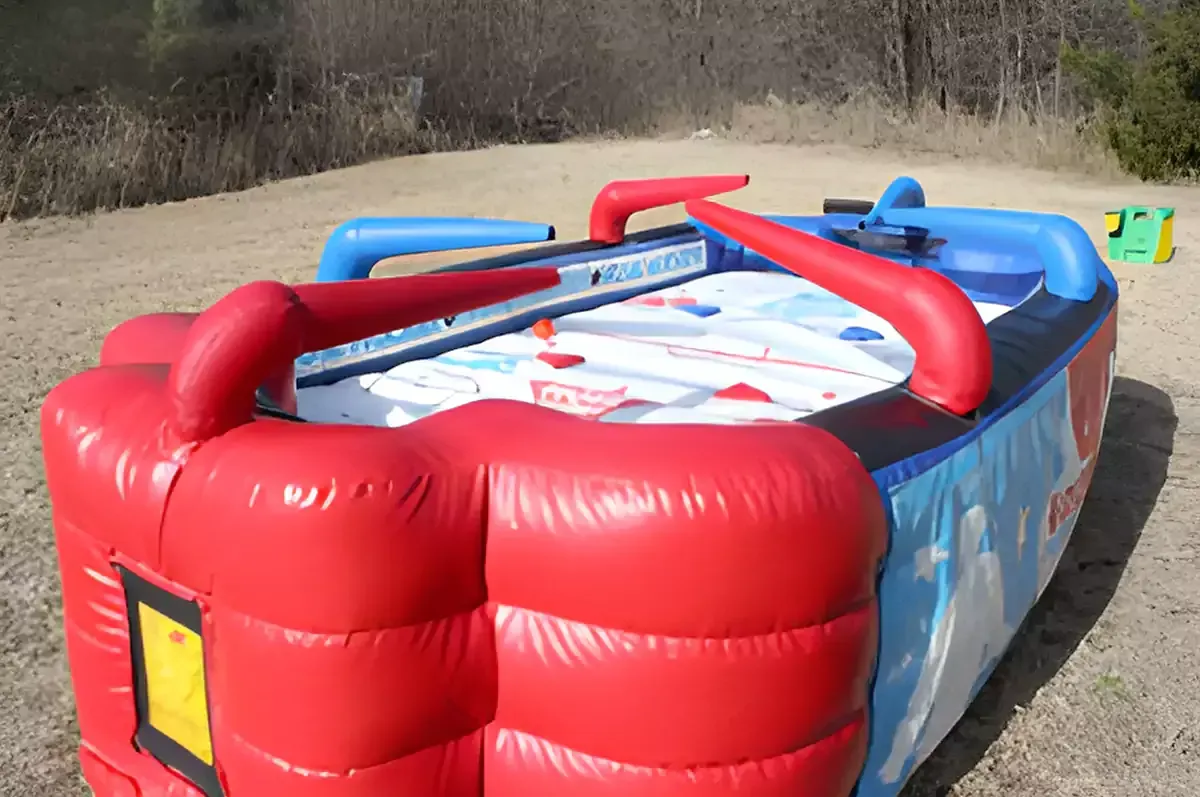 A large inflatable water slide is sitting on top of a lush green field.