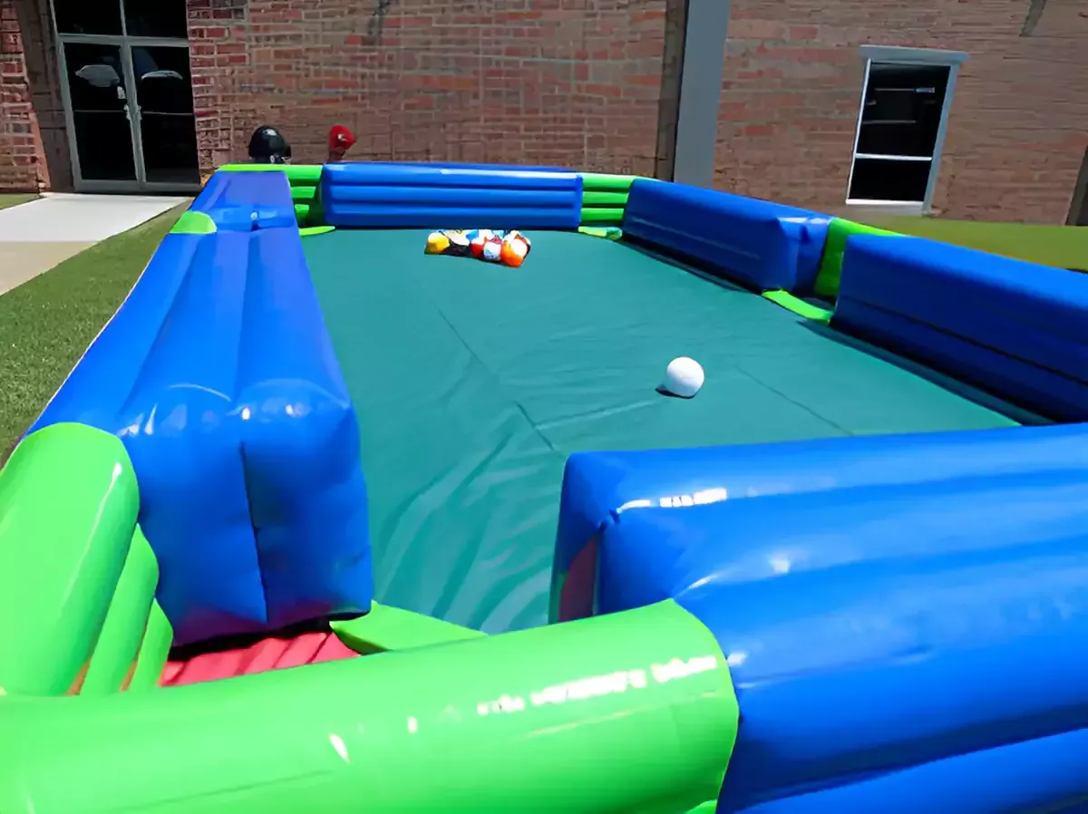 A large inflatable bouncy house with a flamingo and pineapple on it