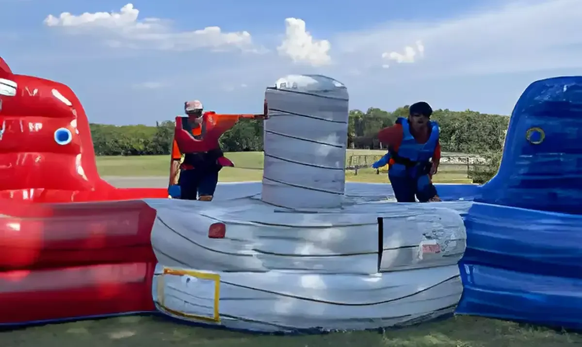 A large inflatable bouncy house with a flamingo and pineapple on it