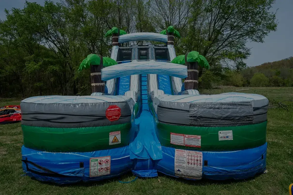 A large inflatable water slide is sitting on top of a lush green field.
