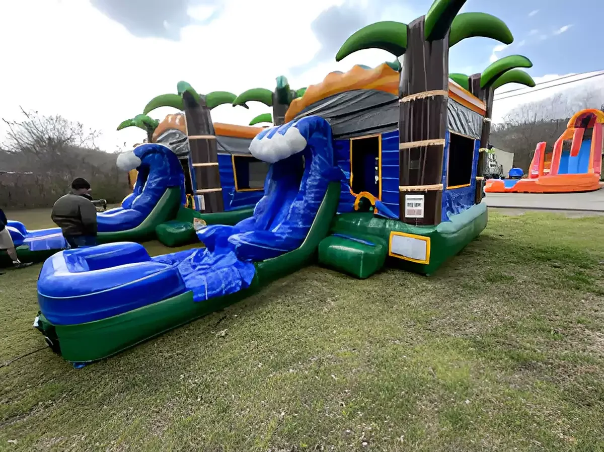 A group of bouncy houses are sitting on top of a lush green field.