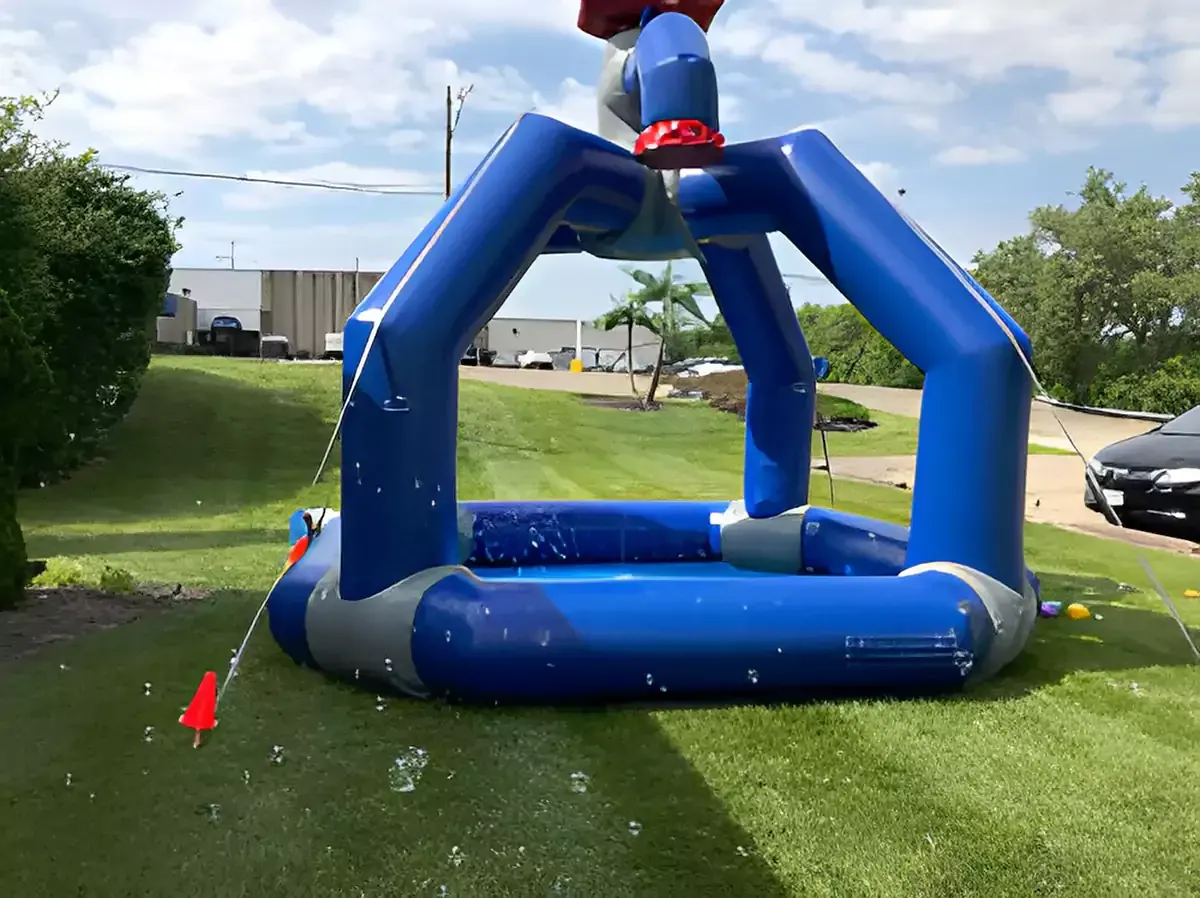 A blue inflatable castle is sitting on top of a lush green field.