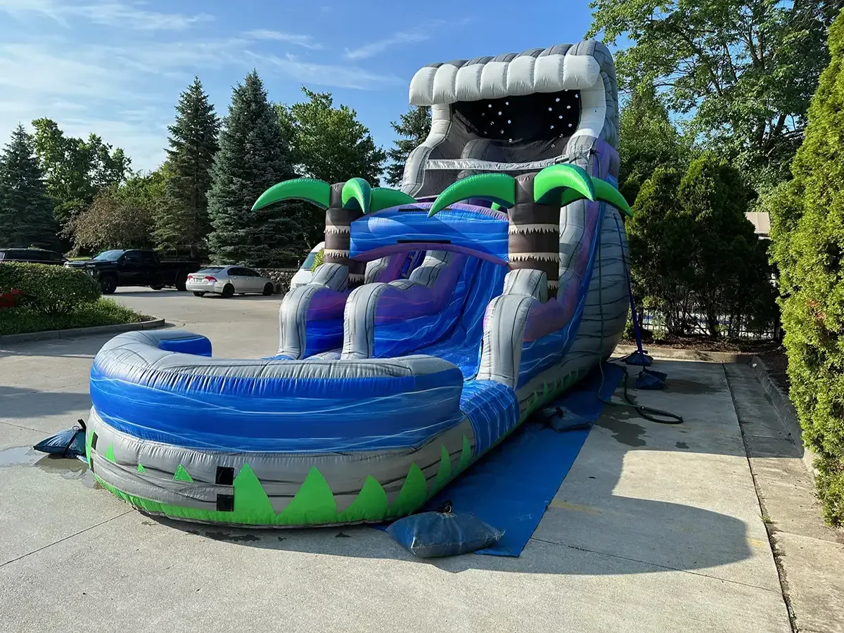 A large inflatable water slide is sitting in a parking lot.