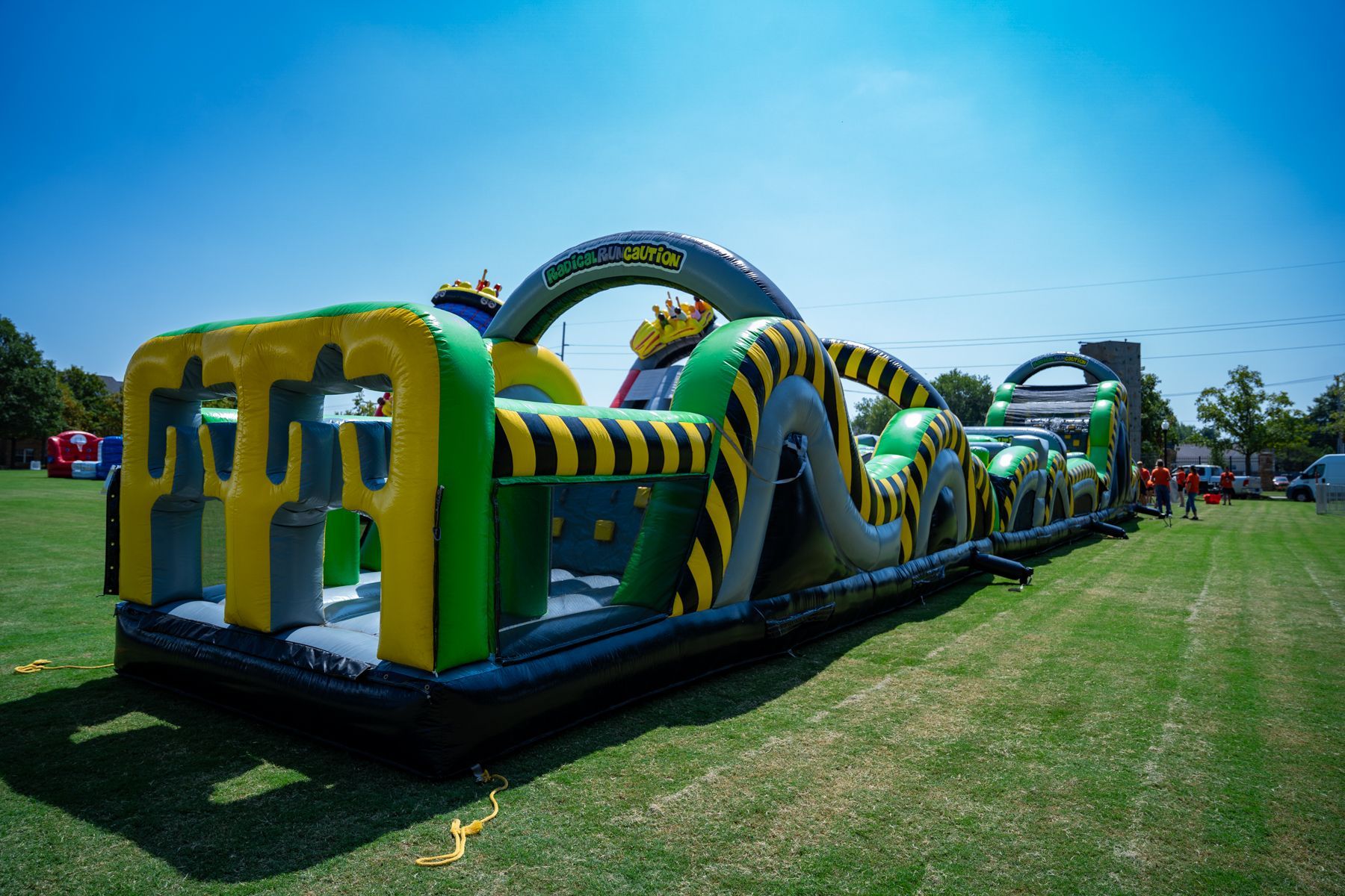 A large inflatable obstacle course is sitting on top of a lush green field.
