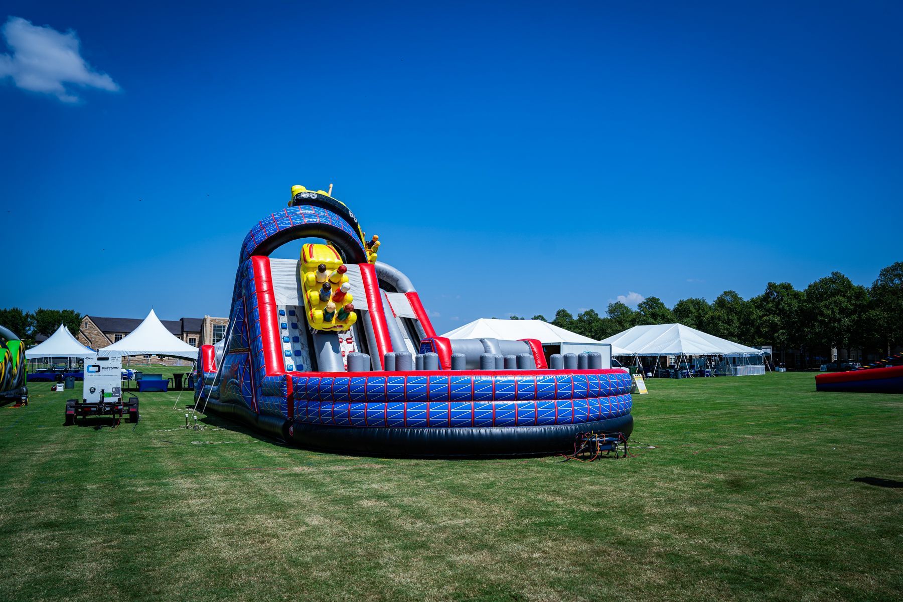A large inflatable slide is sitting in the middle of a grassy field.
