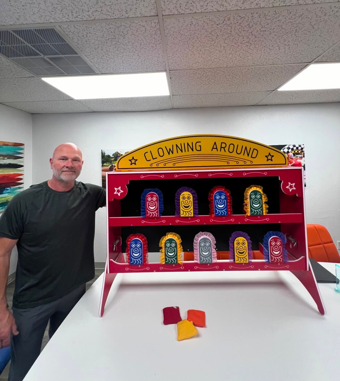 A man stands in front of a clown around display