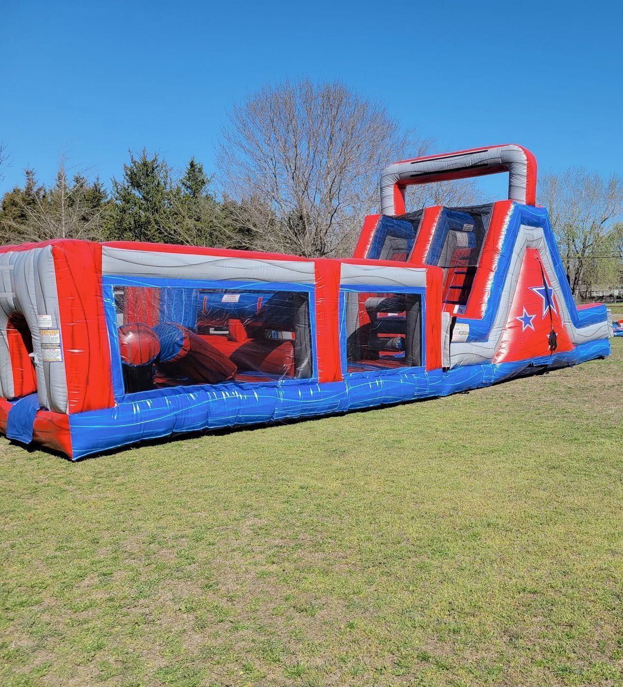 A large inflatable obstacle course is sitting on top of a lush green field.