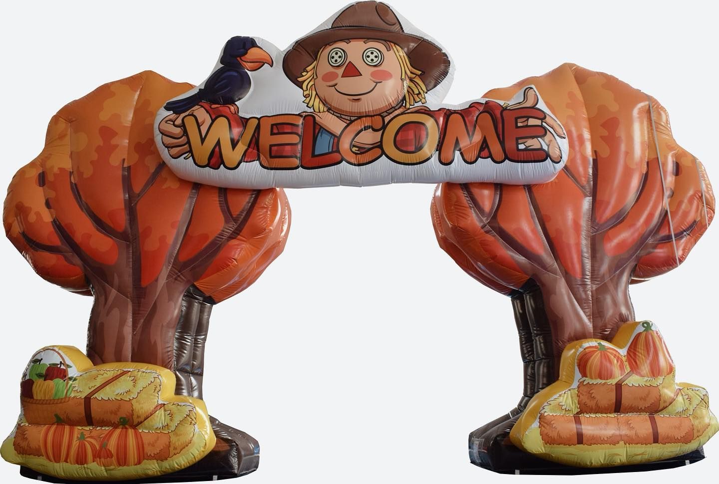 A scarecrow is holding a sign that says welcome