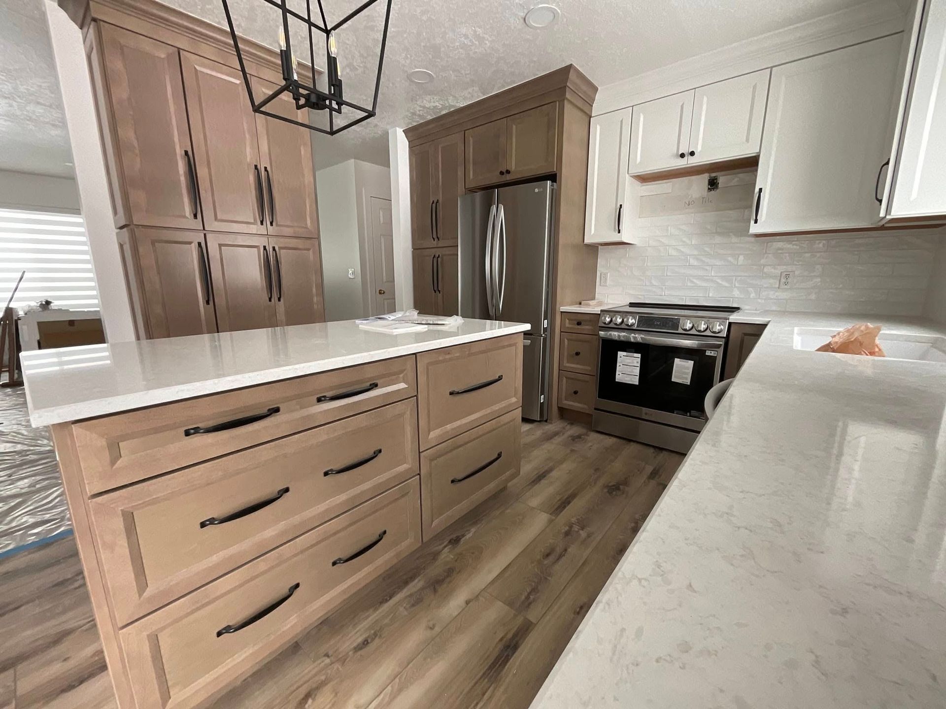 Kitchen with light wood cabinets, stainless steel appliances, and white countertops.