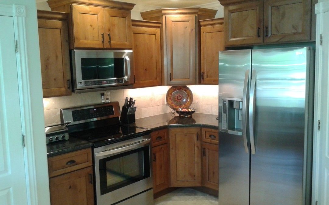 Kitchen with wooden cabinets, stainless steel appliances, and dark countertops.