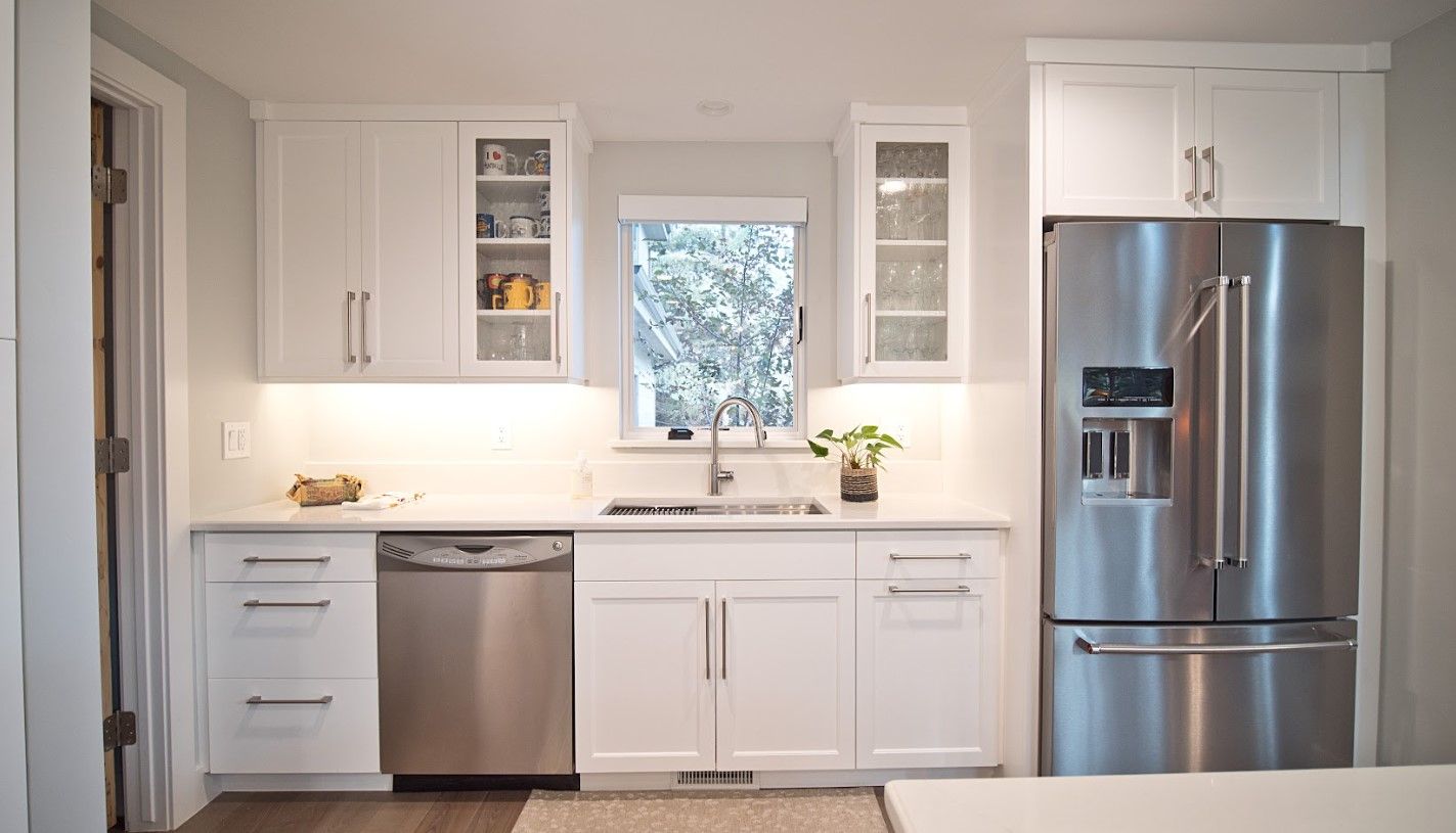 White kitchen with stainless steel appliances and cabinets.