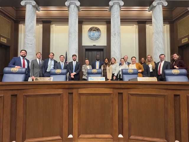 A group of people are posing for a picture in a courtroom.