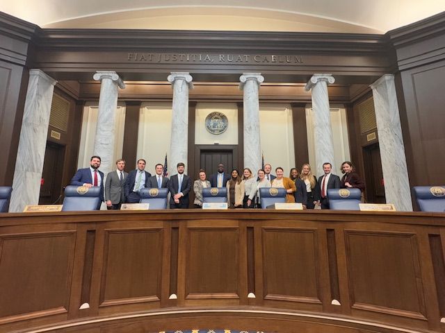 A group of people are posing for a picture in a courtroom.