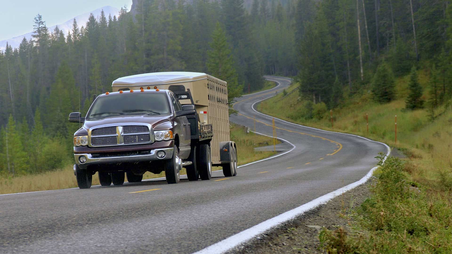 Pickup truck with a trailer on a winding road