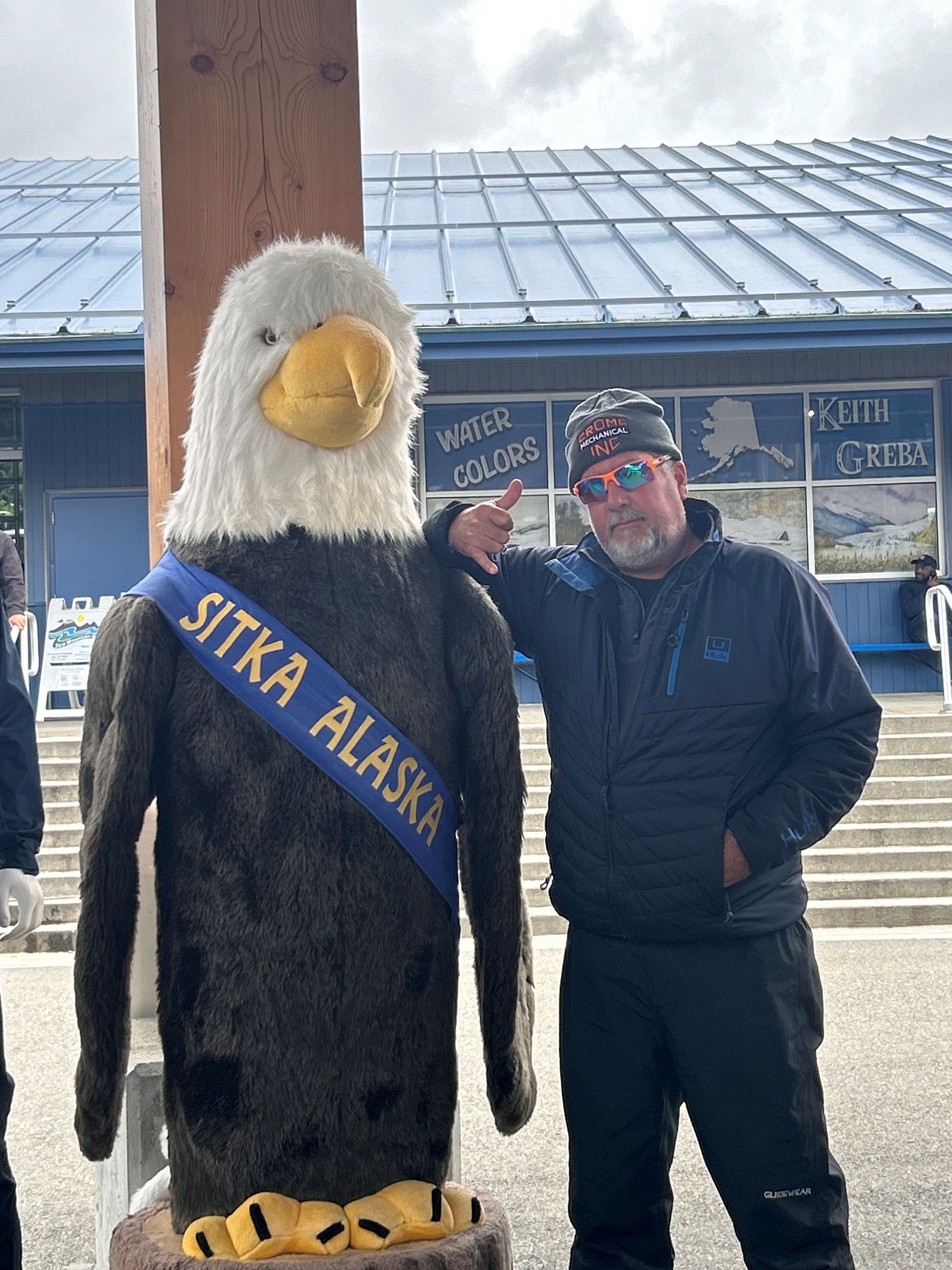 Todd Hurst poses in sunglasses with an Alaska eagle mascot.
