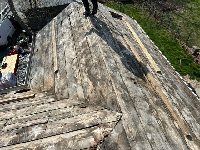 Weathered wooden roof with a small vent chimney, viewed from above.
