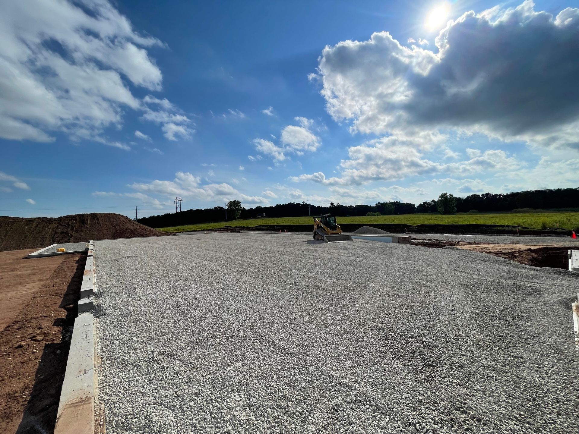 A construction site with gravel and a bulldozer in the background